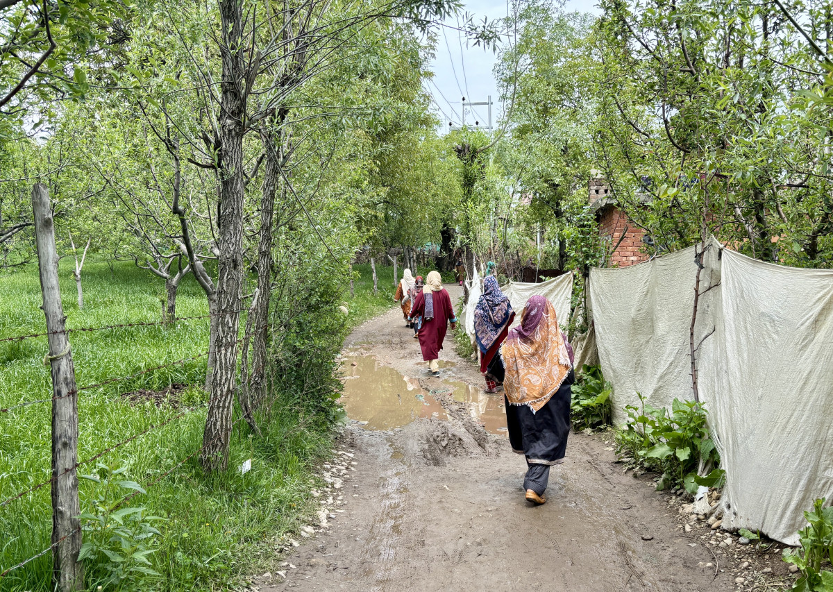 Female mourners negotiating the path to Magraypora locality in Tangmarg village of Kulgam district which is full of puddles. (Photo: Special Arrangement)
